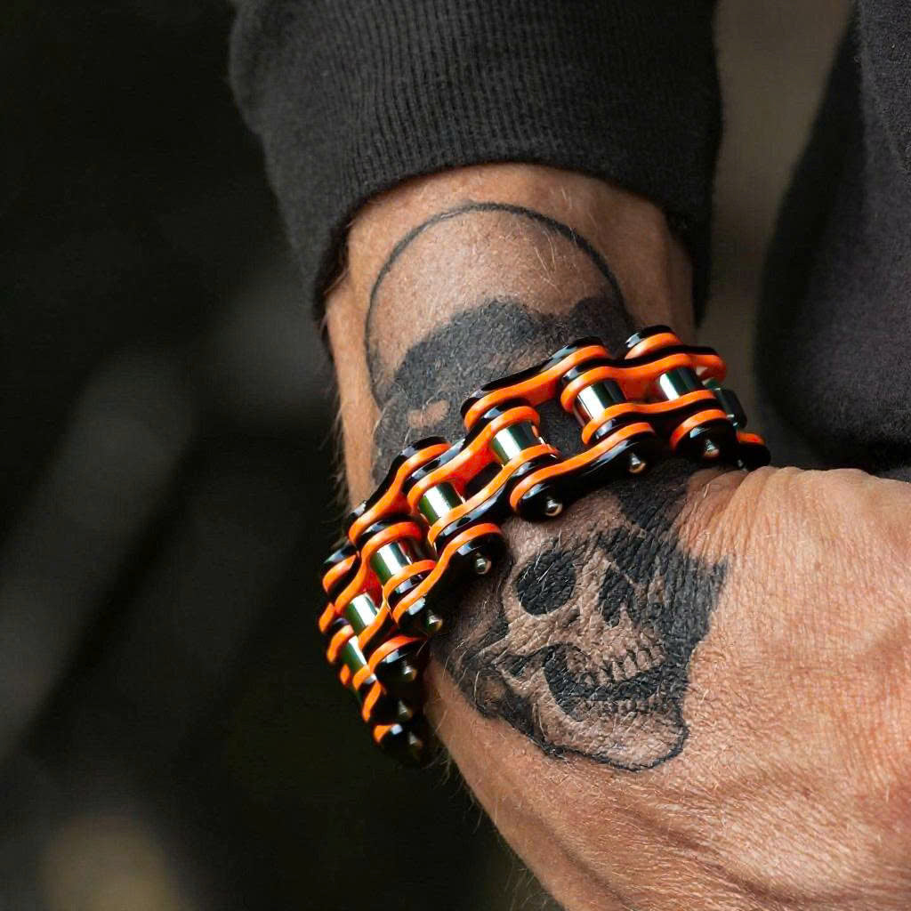 Bracelet with orange and black design on a wrist with tattoos
