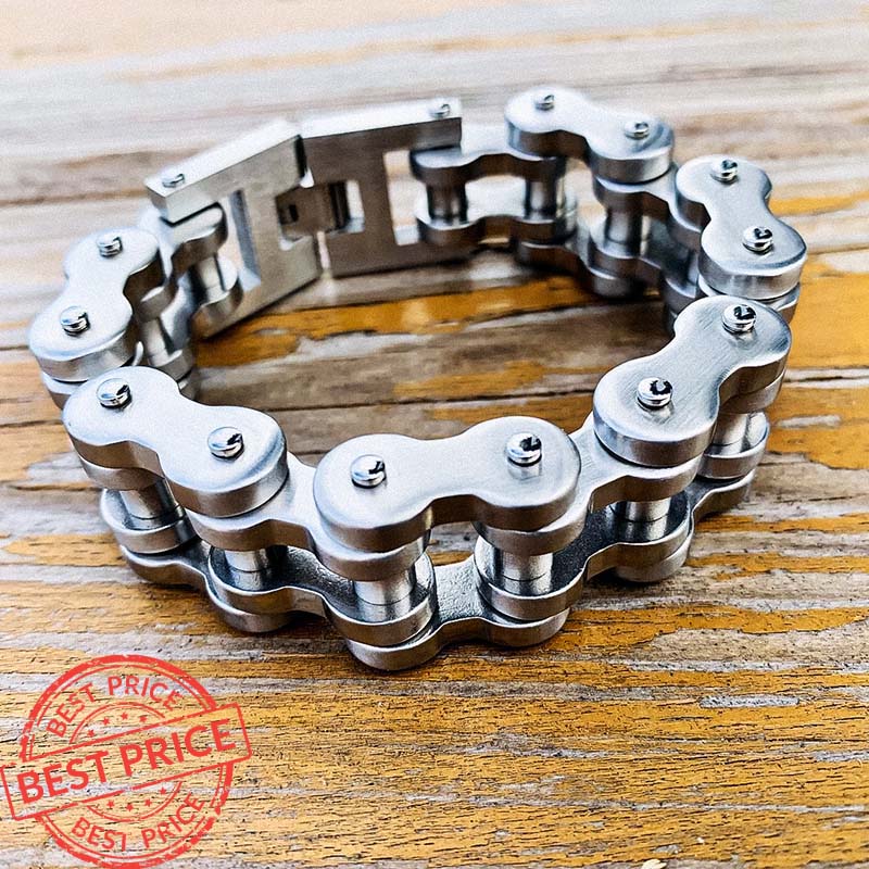 A stainless steel motorcycle chain bracelet displayed on a wooden surface.
