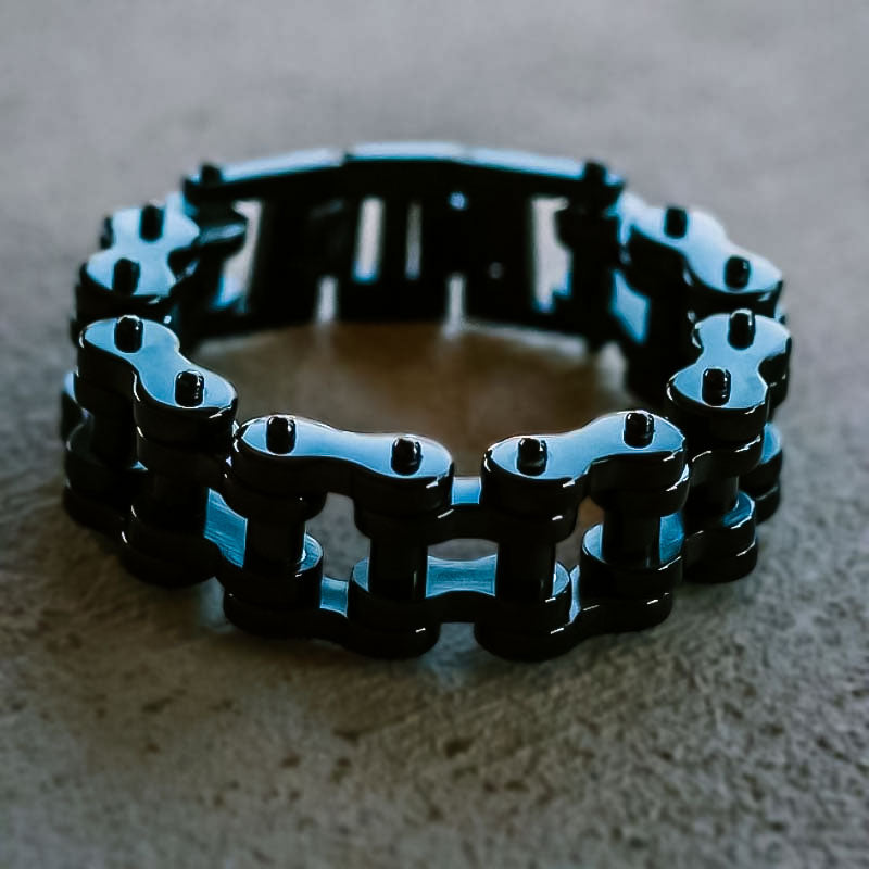 A black vintage motorcycle chain bracelet laid out on a surface.