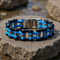 Blue and black chain bracelet on a stone surface with a blurred natural background