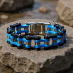 Blue and black chain bracelet on a stone surface with a blurred natural background