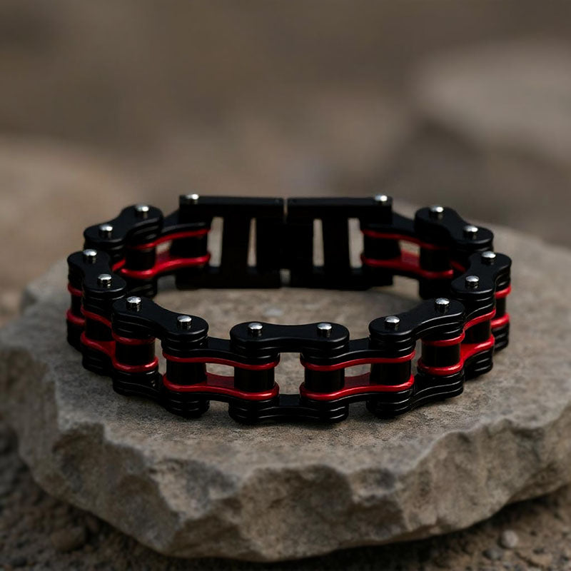 Black and red chain bracelet on a stone surface with a blurred background