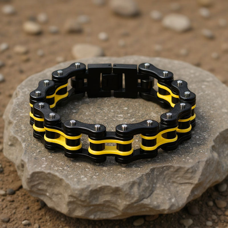 Black and yellow chain bracelet on a stone surface with a natural background