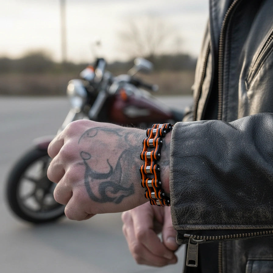 Person wearing a leather jacket and chain bracelet with a tattoo on their arm, standing next to a motorcycle.