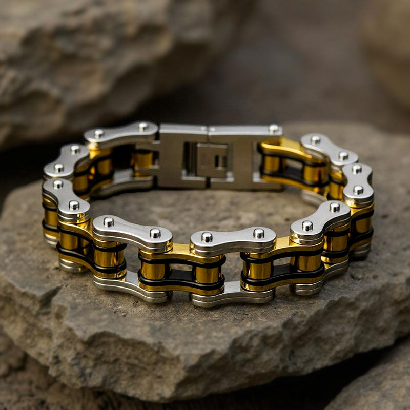 Gold and silver chain bracelet on a stone surface