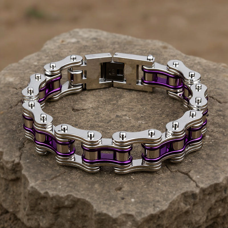 Metallic chain bracelet with purple accents on a stone surface