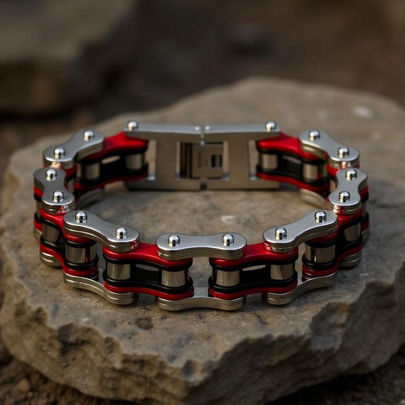 Metallic bracelet with red accents on a stone surface