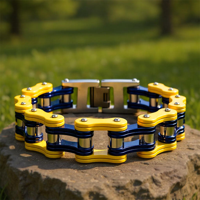 Yellow and black chain-like bracelet on a stone surface with grass in the background